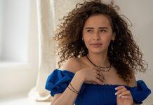 Kobieta w biżuterii MOON LOVE – naszyjnik, bransoletka i pierścionek z czarnymi kamieniami i złotymi elementami. Elegancka stylizacja z niebieską sukienką.